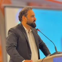 Mr Faizullah Khan speaking at a lectern